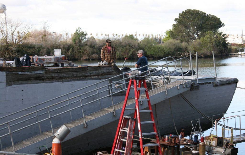 Two people working on a boat in Stockton. Photo by Martha Ozonoff.