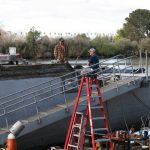 Two people working on a boat in Stockton. Photo by Martha Ozonoff.