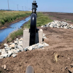 A water recirculation pump installed next to an irrigation ditch.