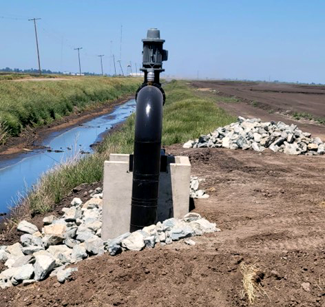 A water recirculation pump installed next to an irrigation ditch.